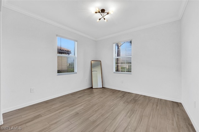 spare room featuring ornamental molding, plenty of natural light, and light hardwood / wood-style floors