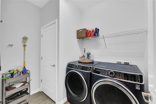 laundry area featuring light hardwood / wood-style flooring and washer and clothes dryer