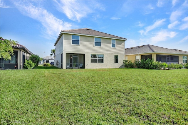 rear view of house featuring a sunroom and a yard