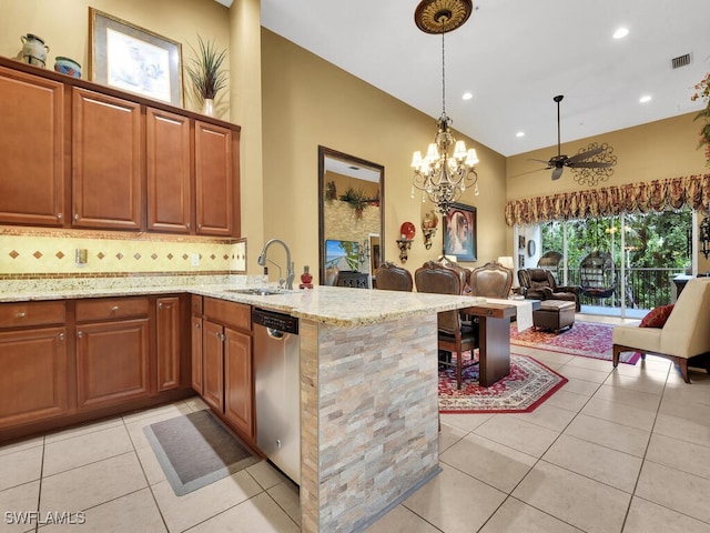 kitchen featuring tasteful backsplash, light tile patterned floors, light stone countertops, dishwasher, and kitchen peninsula