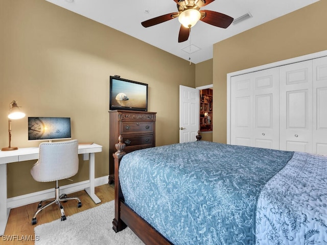 bedroom featuring hardwood / wood-style floors, ceiling fan, built in desk, and a closet