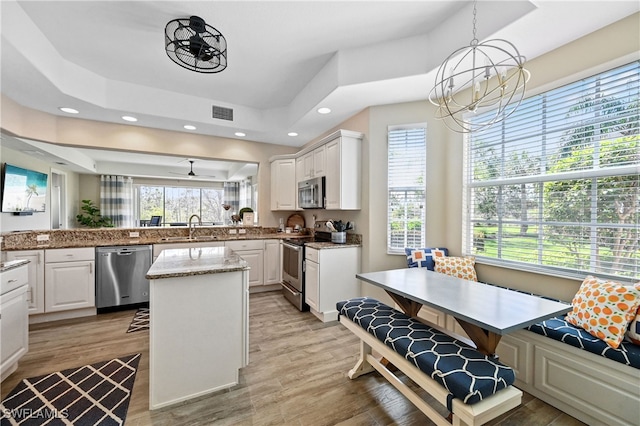 kitchen featuring appliances with stainless steel finishes, breakfast area, light wood-type flooring, and a sink