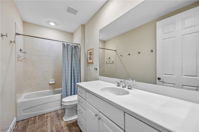 bathroom featuring toilet, wood finished floors, vanity, visible vents, and shower / bath combo