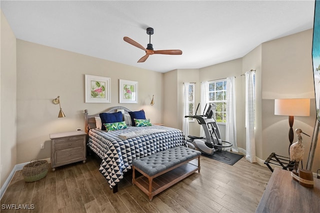 bedroom with wood finished floors, a ceiling fan, and baseboards