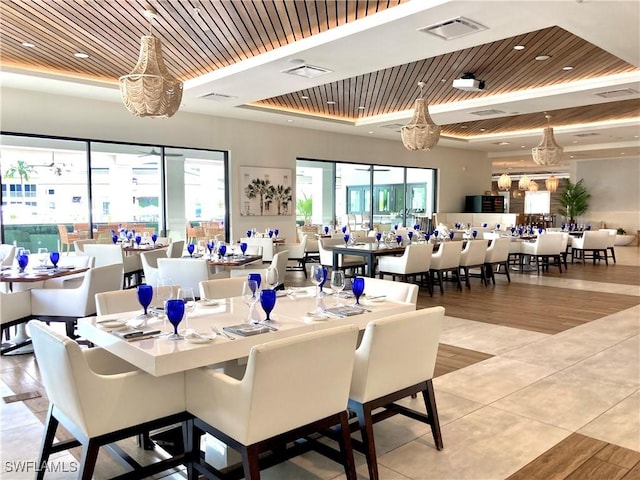 dining space featuring a raised ceiling, wooden ceiling, and plenty of natural light