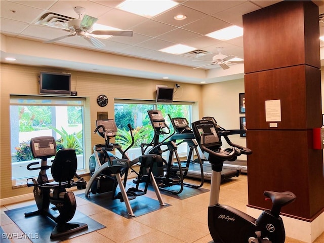 exercise room featuring a paneled ceiling, ceiling fan, and visible vents