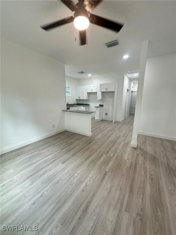 unfurnished living room with ceiling fan and light hardwood / wood-style flooring