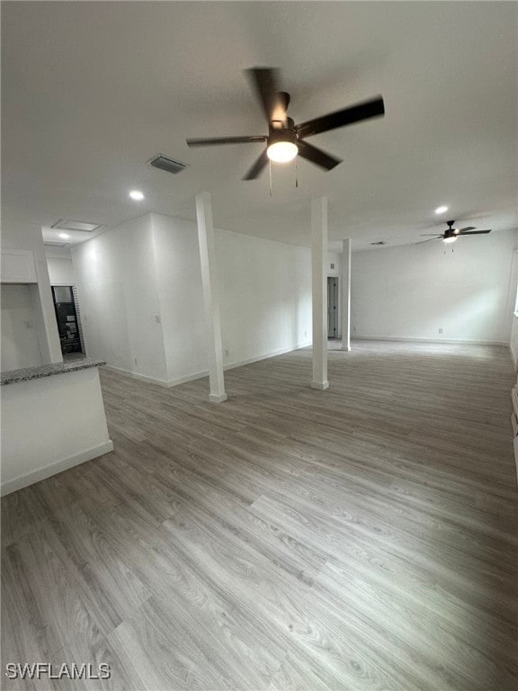 unfurnished living room featuring hardwood / wood-style flooring and ceiling fan