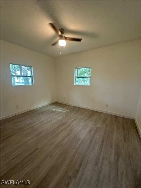 empty room featuring a textured ceiling, dark hardwood / wood-style floors, and ceiling fan