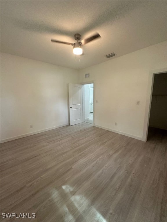 spare room featuring hardwood / wood-style floors, ceiling fan, and a textured ceiling