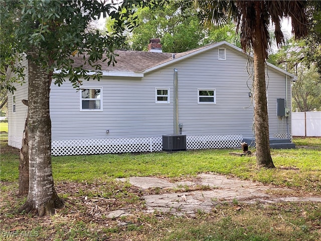 view of home's exterior featuring central AC unit and a yard