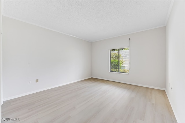 empty room featuring a textured ceiling, light hardwood / wood-style flooring, and crown molding