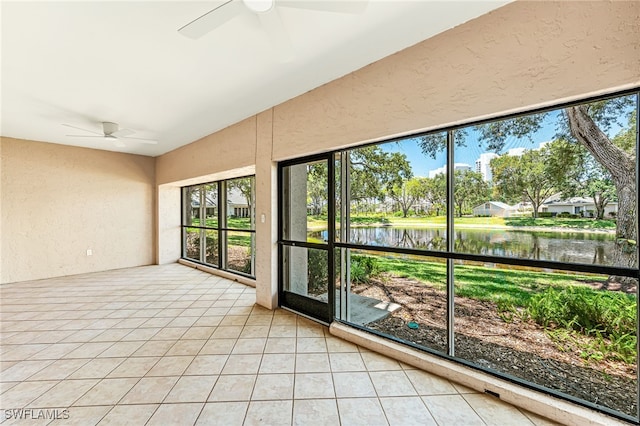 unfurnished sunroom featuring a water view and ceiling fan