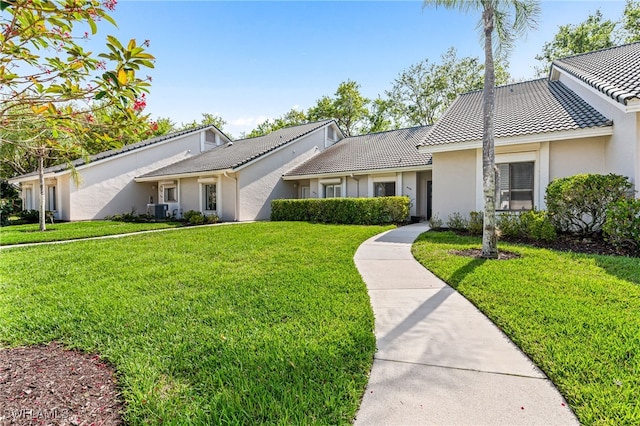 ranch-style home with central air condition unit and a front yard