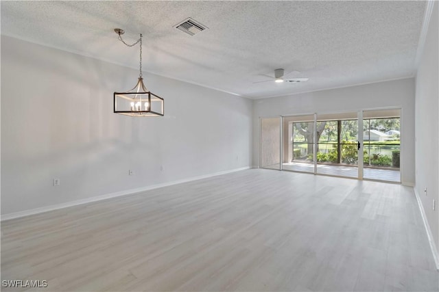 empty room with ceiling fan with notable chandelier, a textured ceiling, and light wood-type flooring