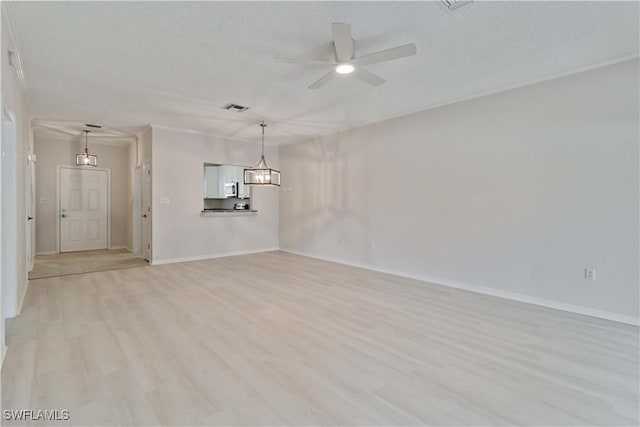 spare room with ceiling fan, a textured ceiling, and light wood-type flooring