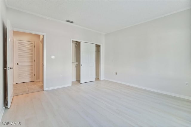 unfurnished bedroom featuring light wood-type flooring and a closet