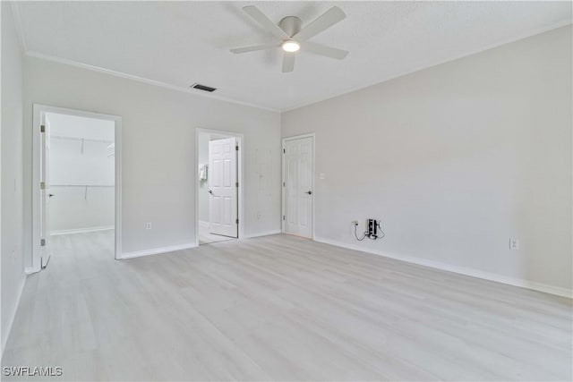 empty room featuring ceiling fan, light hardwood / wood-style floors, and ornamental molding