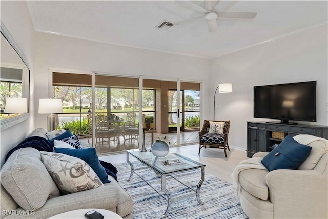 living area featuring ceiling fan, light wood-style flooring, visible vents, and baseboards