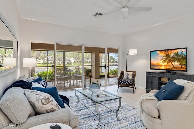 living area with light wood-type flooring, visible vents, baseboards, and ceiling fan