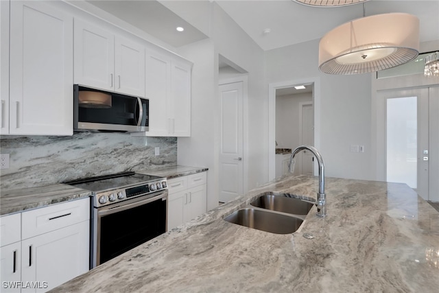 kitchen featuring backsplash, sink, white cabinets, appliances with stainless steel finishes, and light stone counters