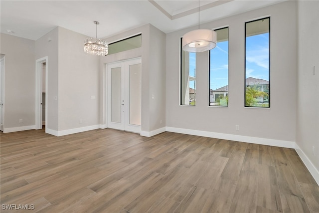 unfurnished dining area featuring light hardwood / wood-style floors and a notable chandelier