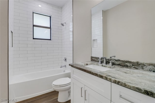 full bathroom with vanity, tiled shower / bath combo, wood-type flooring, and toilet