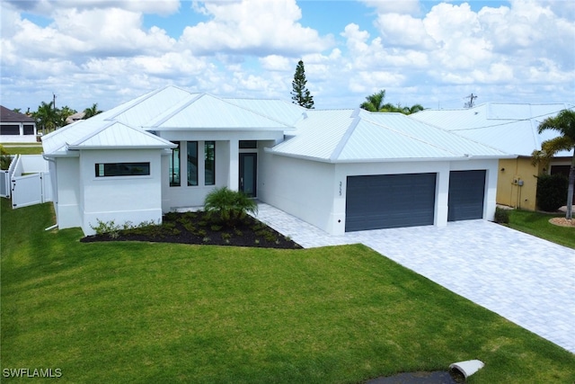 view of front of home with a front yard and a garage