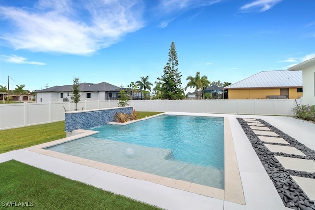 view of pool with pool water feature and a lawn