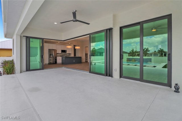 unfurnished living room featuring concrete flooring and ceiling fan