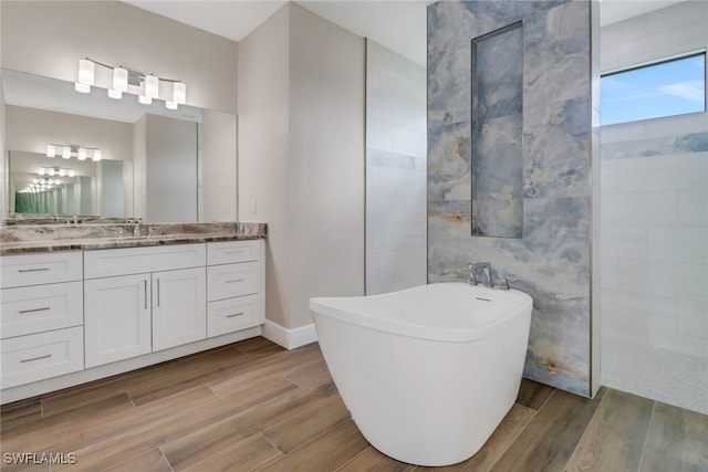 bathroom featuring vanity, plus walk in shower, and wood-type flooring