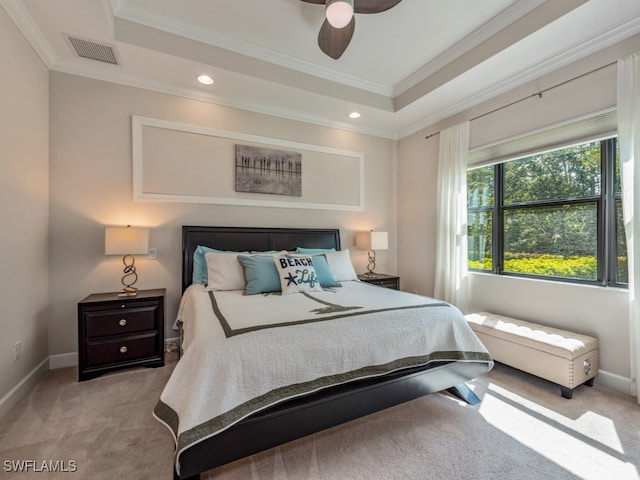 carpeted bedroom featuring ceiling fan, ornamental molding, and a tray ceiling