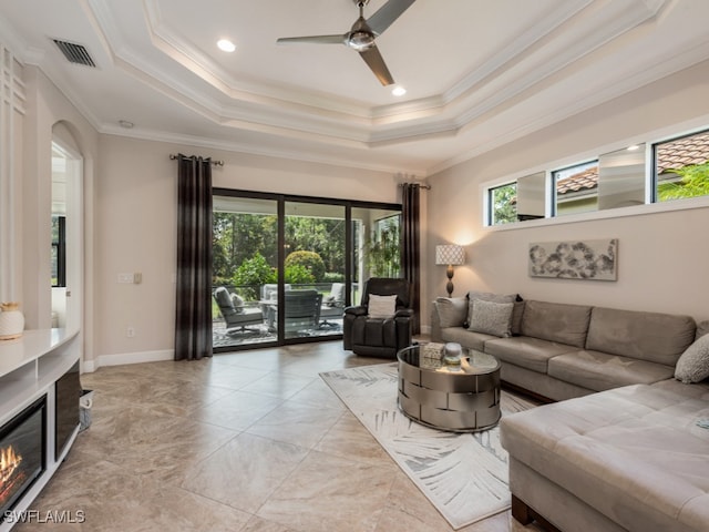 living room featuring crown molding, a tray ceiling, and ceiling fan