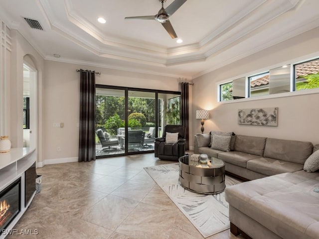 living room featuring crown molding, ceiling fan, and a tray ceiling