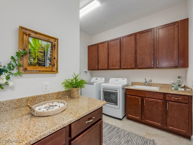 washroom with light tile patterned floors, sink, cabinets, and washer and dryer