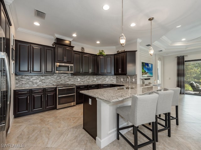 kitchen with ornamental molding, sink, light stone countertops, a breakfast bar, and appliances with stainless steel finishes