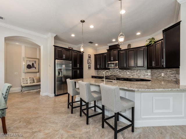 kitchen with crown molding, stainless steel appliances, a kitchen breakfast bar, light stone counters, and hanging light fixtures