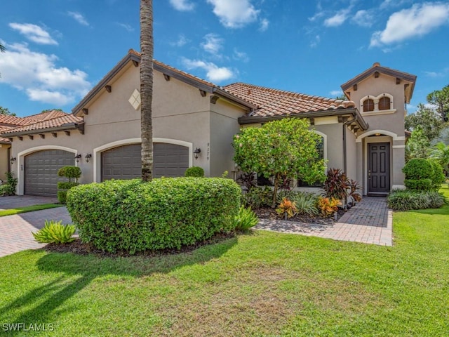 mediterranean / spanish-style home featuring a garage and a front lawn