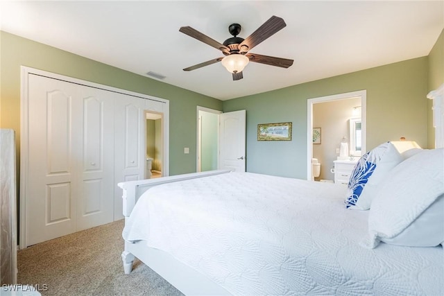 carpeted bedroom with ensuite bathroom, ceiling fan, and a closet