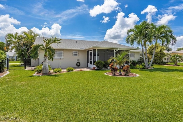 back of property featuring a sunroom and a yard