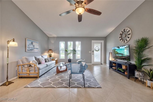 living room featuring ceiling fan, light tile patterned floors, and vaulted ceiling