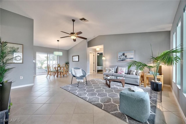 living room featuring ceiling fan, light tile patterned floors, and vaulted ceiling