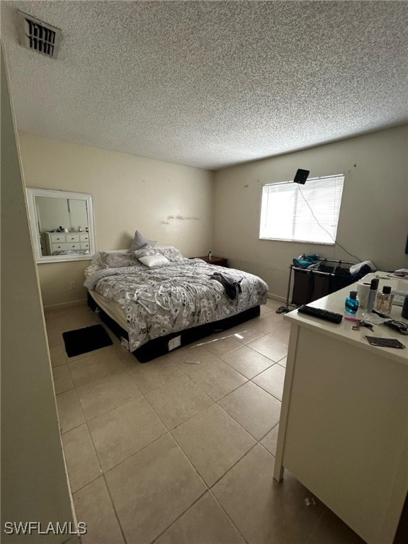 tiled bedroom featuring a textured ceiling