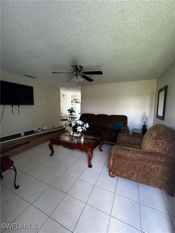 tiled living room featuring a textured ceiling and ceiling fan