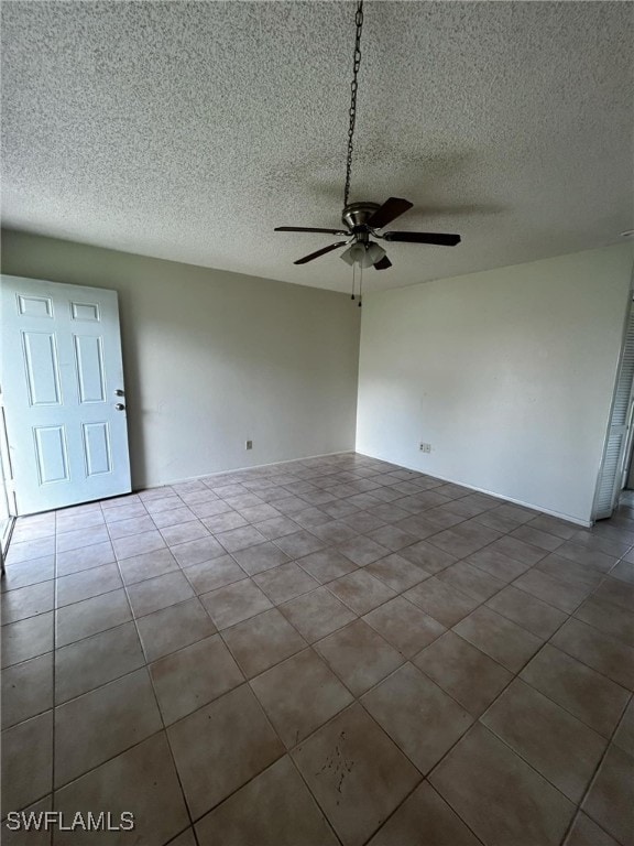 tiled empty room with a textured ceiling and ceiling fan