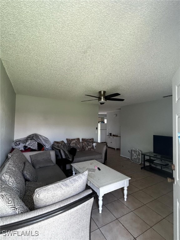 living room with tile patterned floors, ceiling fan, and a textured ceiling