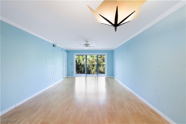 spare room with ornamental molding, light wood-type flooring, ceiling fan, and baseboards