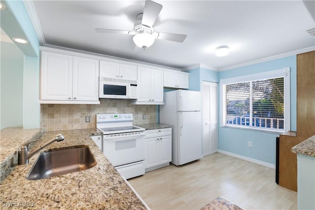 kitchen with white appliances, crown molding, decorative backsplash, and a sink