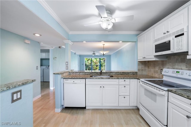 kitchen with ornamental molding, light wood-style floors, white cabinets, a sink, and white appliances