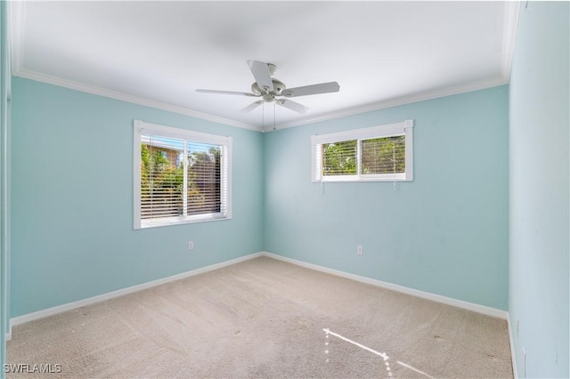 carpeted empty room featuring ornamental molding, ceiling fan, and baseboards